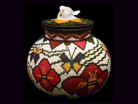 Wounaan handwoven basket features a carved tagua nut hummingbird hovering and feeding on its lid