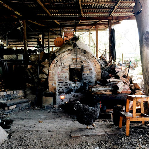 Audrey-the-wood-fire-kiln in the shed with a black chook