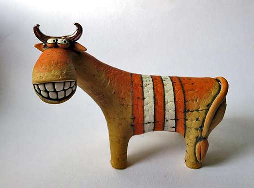 Inna Olshansky smiling ceramic cow sculpture with orange and white stripes