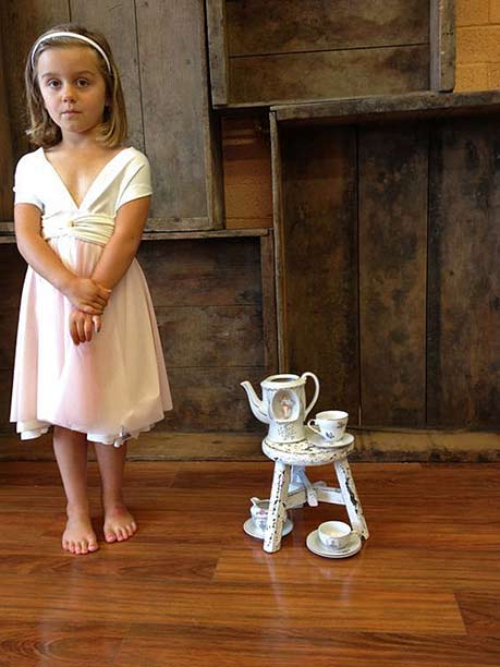 A girl with a tiny play teaset
