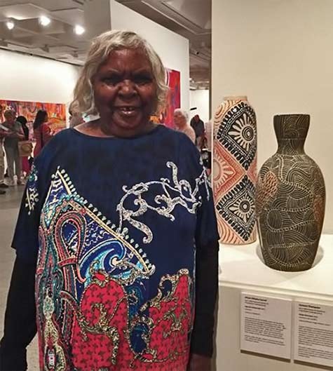 Tjunkaya Tapaya with works by fellow Ernabella women - Alison Milyika Carroll and Carlene Thompson.